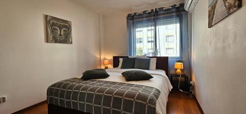 a bedroom with a bed with two pillows and a window at Modern 3 Bed Flat - Beaches, Expo & City Fun - Your Gateway to Lisbon in Montijo
