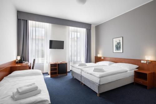 pokój hotelowy z dwoma łóżkami i telewizorem w obiekcie Hotel Beránek w Pradze