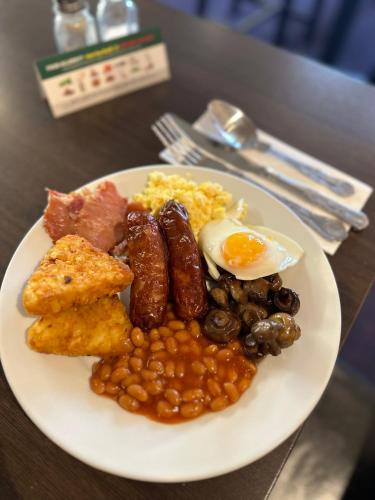 Royal Clifton Hotel في ساوثبورت: طبق من طعام الإفطار مع فول البيض ولحم الخنزير المقدد