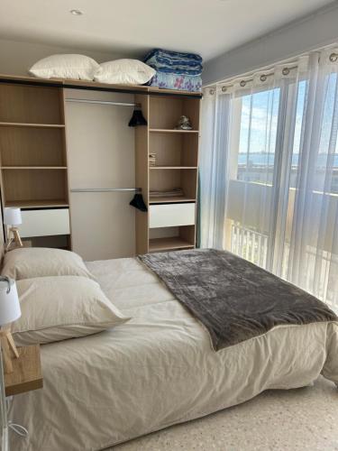 une chambre avec un grand lit et une fenêtre dans l'établissement T2 climatisé face à la cure, à Balaruc-les-Bains