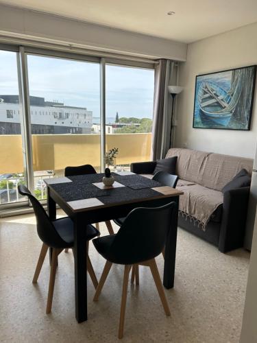 un salon avec une table, des chaises et un canapé dans l'établissement T2 climatisé face à la cure, à Balaruc-les-Bains