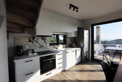 a kitchen with white cabinets and a view of a patio at Skiti Villas Green Holidays in Skíti