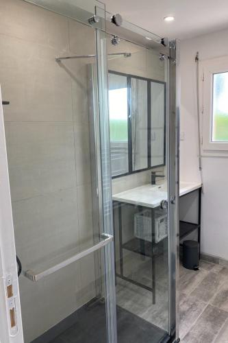 une salle de bain avec une douche en verre et un lavabo dans l'établissement Maison face à l'océan, à Sarzeau