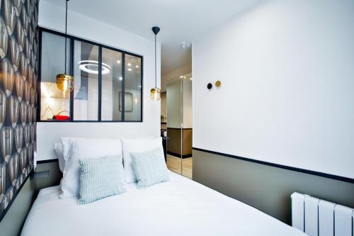 une chambre avec un lit blanc avec deux oreillers dans l'établissement WS Opéra - Duphot, à Paris