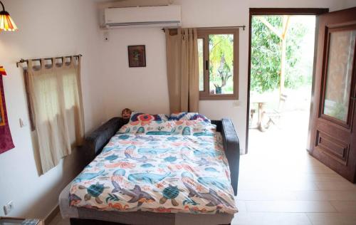 a bedroom with a bed with a colorful comforter at A cozy studio in Pardes Hanna in Pardes H̱anna