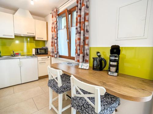 a kitchen with a wooden table and chairs at Apartments Haus Morgensonne in Reidling