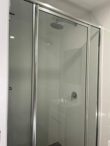 a shower with a glass door in a bathroom at Beachside Bedstay in Emerald Beach