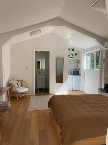 a bedroom with a large bed and a kitchen at Beachside Bedstay in Emerald Beach