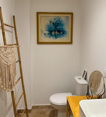 une salle de bain avec toilettes et un tableau au mur dans l'établissement Villa Hawwah, à Sète