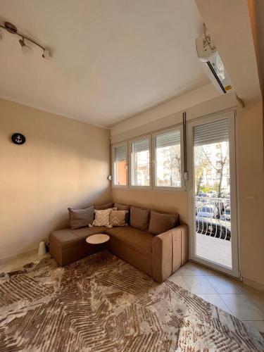 a living room with a couch and a window at Apartment City in Tivat