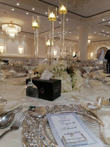 a table with silverware and a bottle of wine on it at Hyksos Hotel in Erbil