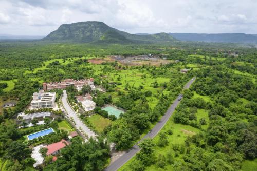 an aerial view of a resort with mountains in the background at juSTa Rudra Resort & Spa in Kolād