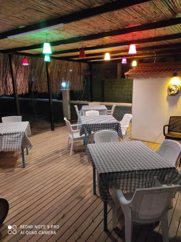 a restaurant with tables and chairs on a wooden deck at mila's home in Seferihisar
