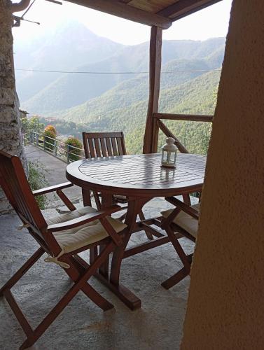 a table and two chairs on a porch with a view at Agriturismo U' Spigu Nonna Annetta in Nasino