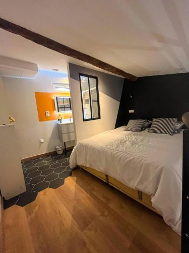 une chambre avec un grand lit avec une tête de lit noire dans l'établissement Maison de Ville Nid Cosy, à Chavanay