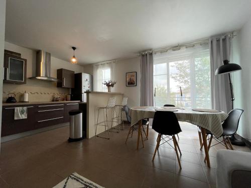 une cuisine et une salle à manger avec une table et des chaises dans l'établissement Duplex Moderne 8per&3Ch&10 min Disney&Parking free, à Magny-le-Hongre