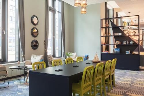 a room with a table and yellow chairs at Holiday Inn - the niu, Yen Hamburg City by IHG in Hamburg