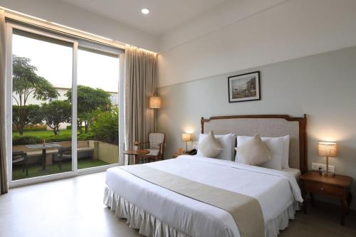 a bedroom with a large bed and a large window at juSTa Rudra Resort & Spa in Kolād