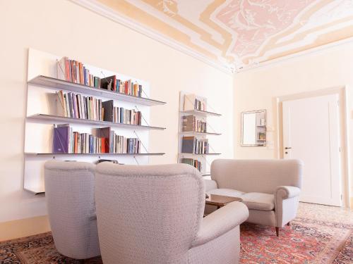 a living room with two chairs and a book shelf at Palazzetto Pisani Grand Canal in Venice