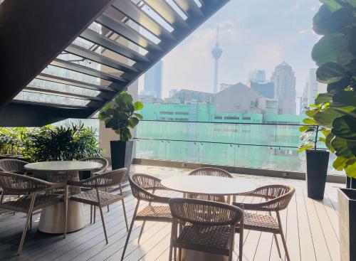 a patio with tables and chairs and a view of the city at Axon Residence KLCC - KL HOME in Kuala Lumpur