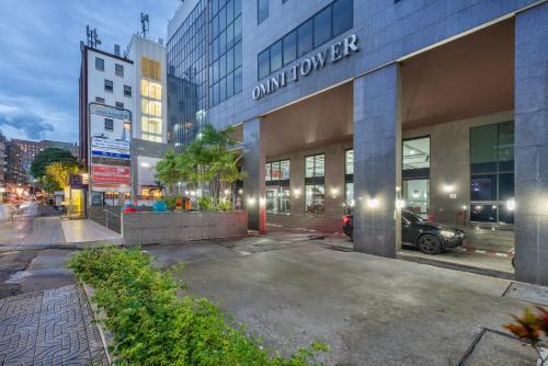 バンコクにあるNeom Town Residenceの建物の前に車が駐車されている