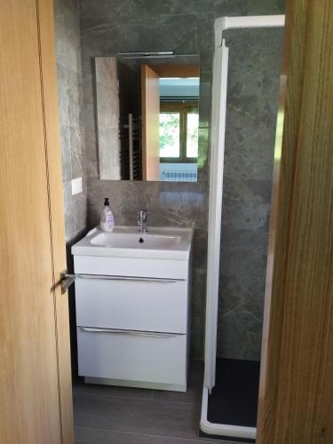 a bathroom with a white sink and a mirror at Casa aparicio in Cudillero