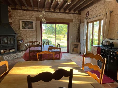 une cuisine et une salle à manger avec une table et des chaises dans l'établissement Grande Maison en bord de Seine, à Muids
