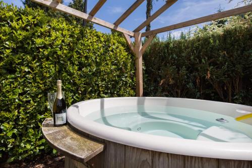 a bath tub with a bottle of wine sitting in it at GREAT STAY - NATURE - Outside HOTTUB en SAUNA in Voorthuizen