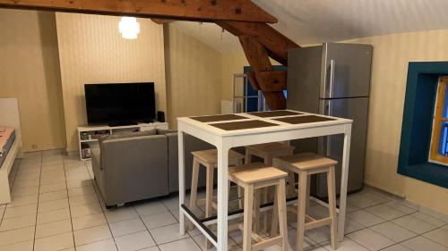 La cuisine est équipée d'un réfrigérateur, d'une table et de tabourets. dans l'établissement Bonheur, à Lyon