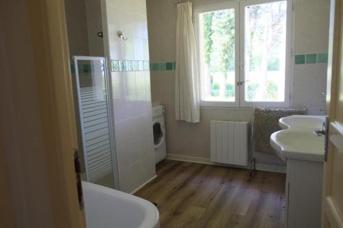 a bathroom with a sink and a washing machine at les portes des Froises in Saint-Quentin-en-Tourmont