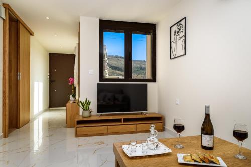 a living room with a television and two glasses of wine at Nicolas Urban Luxury Living in Souda