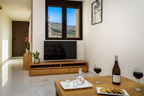 a living room with a tv and a table with wine glasses at Nicolas Urban Luxury Living in Souda