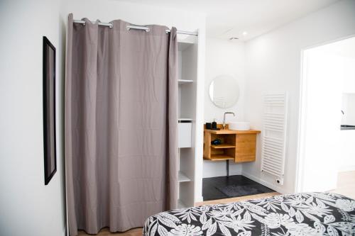- une chambre avec un rideau de douche à côté d'un lit dans l'établissement Charment T2 avec extérieur à 200m du Tram C, à Le Bouscat