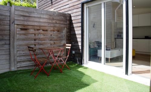 un patio avec une table et des chaises sur l'herbe dans l'établissement Charment T2 avec extérieur à 200m du Tram C, à Le Bouscat