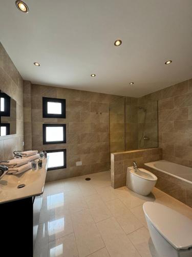 a bathroom with a tub and a toilet and a sink at Nazaret Home in Nazaret