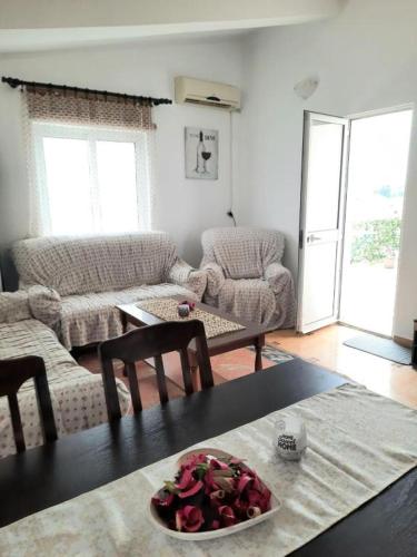 a living room with a table with a bowl of roses on it at Šušanj Ilino APARTMAN in Bar