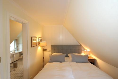 a bedroom with a white bed with two pillows at Boutiquehotel Seiler Hof Keitum in Keitum