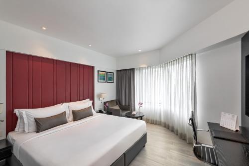 a bedroom with a large bed and a red wall at Hotel Suncity Residency in Mumbai