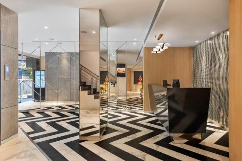 a lobby with a black and white patterned floor at Hotel Suncity Residency in Mumbai