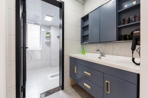 a bathroom with a sink and a shower at Heavens Gate homestay free pick up service from train station and airport in Zhangjiajie