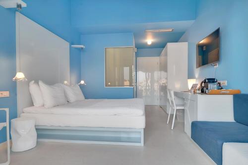 a blue bedroom with a white bed and a kitchen at SESA Boutique Hotel & Restaurant in Kanali