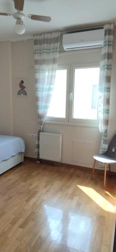 a bedroom with a bed and two large windows at Η πέρλα της λίμνης/ The lake's pearl in Ioannina
