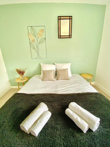 une chambre avec un grand lit avec deux oreillers dessus dans l'établissement L'Artiste T3 lumineux et spacieux, à Limoges