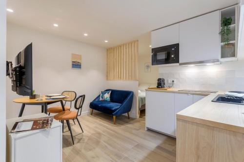 une cuisine avec une chaise bleue et une table dans l'établissement Cozy Studio - Heart of the Traboule, à Lyon