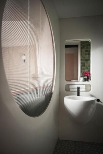 a bathroom with a white sink and a mirror at DuoMo Hotel in Rimini