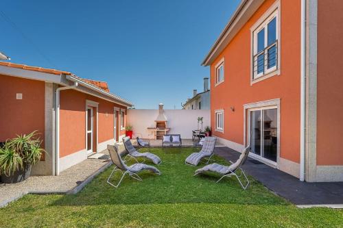 a group of chairs sitting on a lawn next to a building at GuestReady - Esposende Dreamy Retreat in Esposende