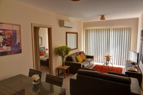 a living room with a couch and a table at Aphrodite Sands in Mandria
