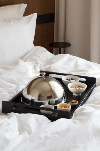 a tray of food on a bed with bowls of food at Monist Palanga boutique by SPA VILNIUS in Palanga