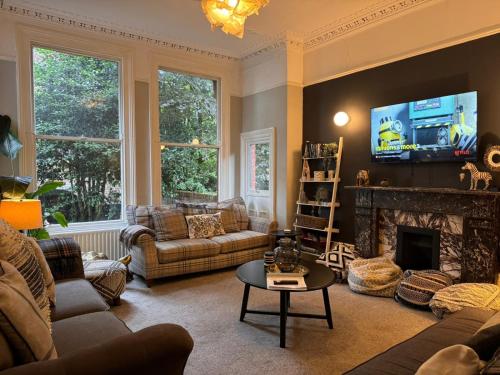 a living room with a couch and a fireplace at Deluxe Huge Detached House with Parking, sleeps up to 30 people, 2m from Liverpool City Centre in Liverpool