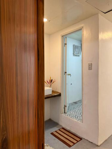 a hallway with a door and a mirror at La Greta El Nido Apartments in El Nido